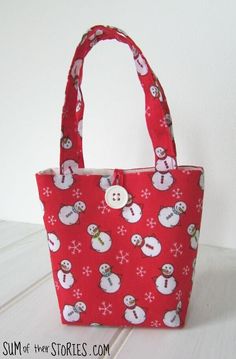 a red bag with white snowmen on it and a button in the front pocket