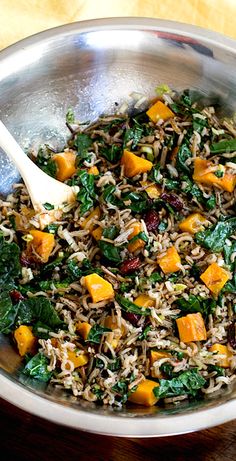 a pan filled with rice and vegetables on top of a wooden table