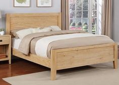 a wooden bed frame in a bedroom with hardwood flooring and walls painted light blue