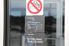 a no food drinks or pets allowed sign is posted on the glass door of a building