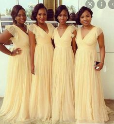 four women in long dresses posing for the camera