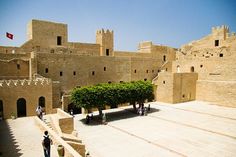 people are standing in front of an old castle