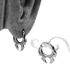 two pairs of silver hoop earrings on top of a white background with an image of a woman's face in the background