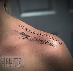 the back of a man's shoulder with roman numerals tattoo on it