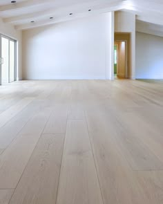 an empty room with white walls and wood flooring is seen in this image from the inside