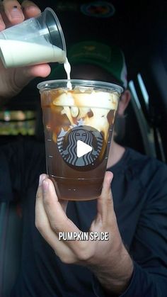 a man pouring coffee into a cup with the words pumpkin spice written on it in front of him