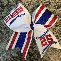 a baseball ribbon with the number 25 on it and diamond's in red, white, and blue