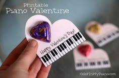 a hand holding a valentine's day card with hearts and piano keys on it