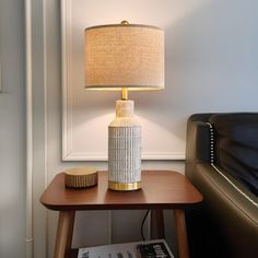 a lamp sitting on top of a table next to a couch