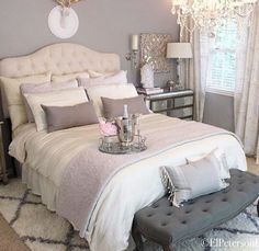 a bedroom with a large bed and chandelier