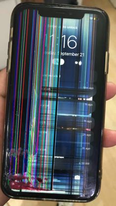 someone is holding up their cell phone with colorful lines on the screen and back side