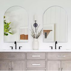 a bathroom with double sinks and mirrors on the wall