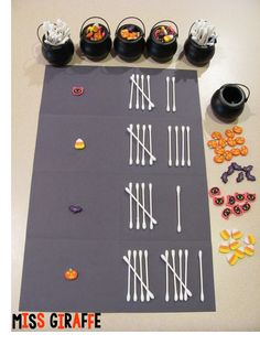 a table topped with lots of candy and candies next to black pots on top of it