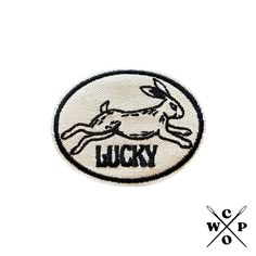 a white and black patch with the word lucky printed on it's back side