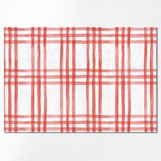 a red and white checkered table cloth on a white surface with an orange stripe