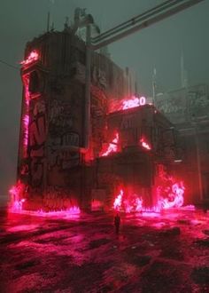 a man standing in front of an industrial building with red lights and graffiti on it