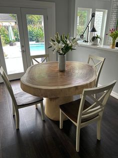 a wooden table with chairs around it in front of a sliding glass door that leads to a pool