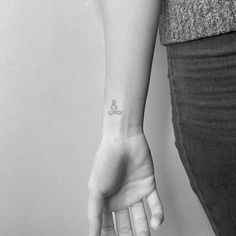 a woman's arm with a small tattoo on the left side of her wrist