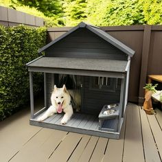 a dog is sitting in his kennel on the back deck with its tongue hanging out