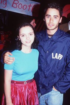 a man and woman standing next to each other in front of a sign that says larp