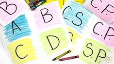 children's handwritten letters and crayons on top of paper with pencils