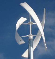 a white wind turbine on top of a blue sky with clouds in the back ground