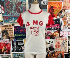 "Vintage 1960s-70s white and red short sleeve 4MG cartoon cat team jersey graphic ringer crewneck t-shirt by Athletic Wear by Mason. Made in U.S.A. Tagged size 34-36, but estimate it to fit a women's size XXS-XS. Has a small spot on front left, and a couple of interior spots that faintly show on exterior.  manufacturer | Athletic Wear by Mason -- made in U.S.A. tag size | 34-36 -- est. it to fit women's XXS to XS *check measurements measurements: chest -- 31\" total length -- 22\"" Team Jersey, Red Shorts, White And Red, Cartoon Cat, Vintage 1960s, Jersey T Shirt, Womens Clothing Tops, Vintage Inspired