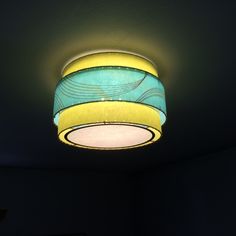 a light that is on the ceiling in a room with dark walls and flooring