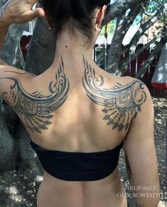 a woman with tattoos on her back