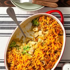 a casserole dish with broccoli, cheese and meat in it on a striped place mat