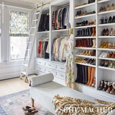 a white closet filled with lots of shoes next to a window and ladder in front of it