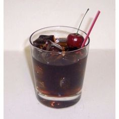 a glass filled with liquid and two cherries