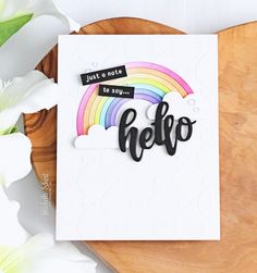 a card with the word hello written in black on it and a flower next to it