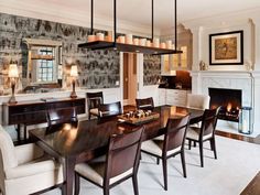 a large dining room table and chairs in front of a fireplace