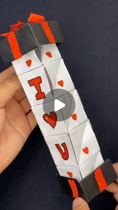 someone is holding an origami piece with the word i love you on it