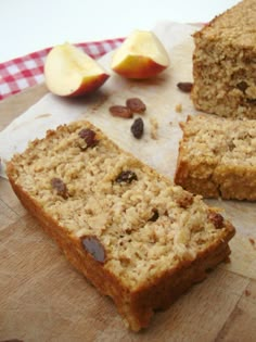 some food is sitting on a cutting board next to an apple and two pieces of bread