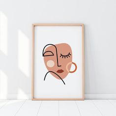 an art print with a woman's face on the wall next to a wooden frame