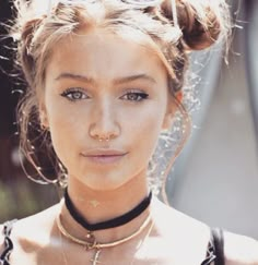 a young woman wearing sunglasses and a choker