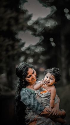 a woman holding a small child in her arms