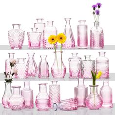 a shelf filled with lots of pink glass vases and yellow flowers on top of them