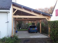 a car is parked in the driveway under an attached carport with a wooden roof