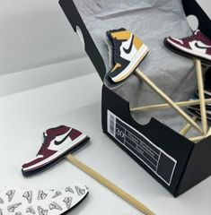 a pair of sneakers are sitting in a shoe box next to matchesticks and paper clips