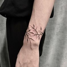 a person's hand with a tattoo on it, holding onto the arm of another person