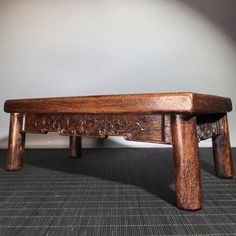 a wooden bench sitting on top of a carpeted floor