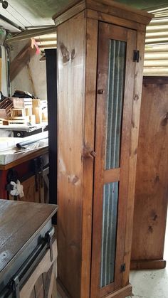 a tall wooden cabinet sitting next to a table