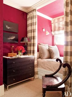 a bedroom with pink walls and striped curtains