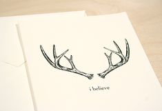 two deer antlers with the words i believe written in black ink on white paper