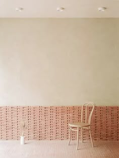 a chair sitting in the middle of a room next to a wall with bricks on it