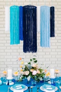 a woman standing in front of a table with blue and white decorations hanging from it