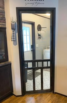 the front door to a home with wood flooring and black iron gated entryway